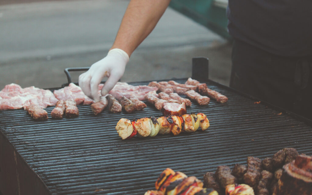 Man touching grill with thin glove.