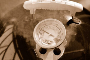 Open vent on barbecue grill lid.