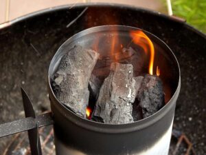 Lit charcoal in a chimney starter.